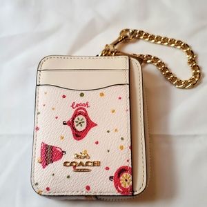 Coach Holiday zip card case with ornament print.